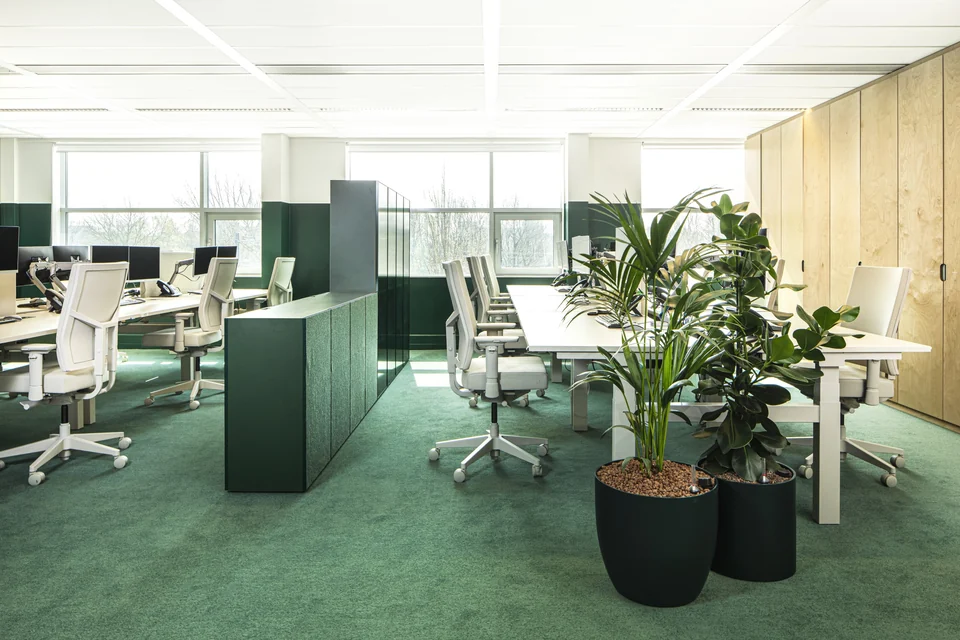 Aidsfonds, Amsterdam, door Hollandse Nieuwe: groene vloerbedekking, groene kasten en planten rond grijze Boring bureaus en stoelen